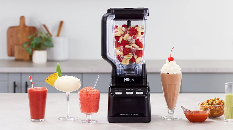 Ninja Professional Blender on a counter surrounded by fresh fruit smoothies.