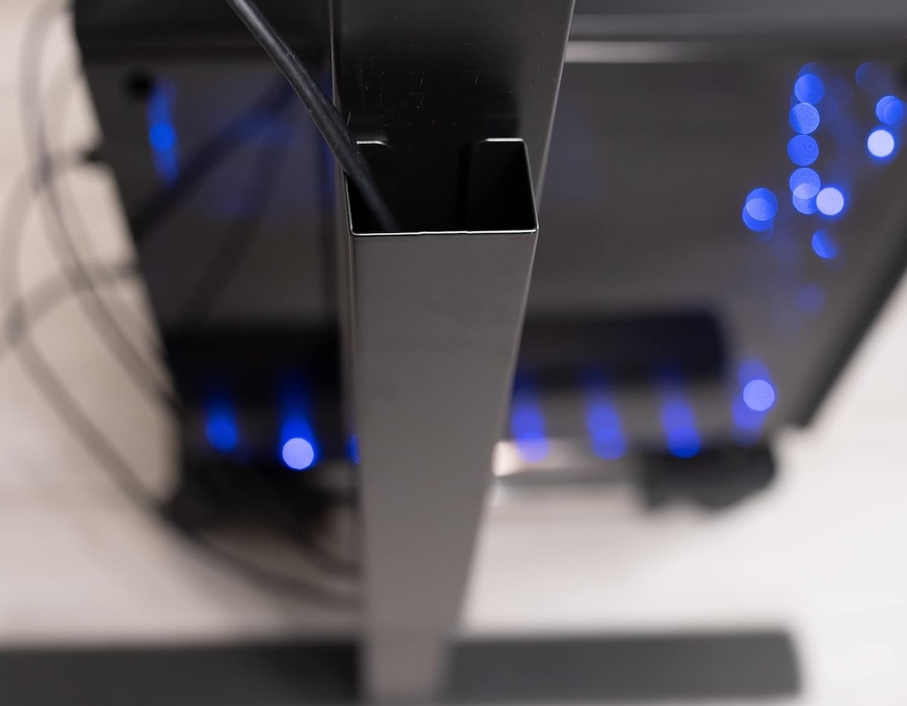 A magnetic steel cable channel attached vertically to a desk leg to hide trailing wires.