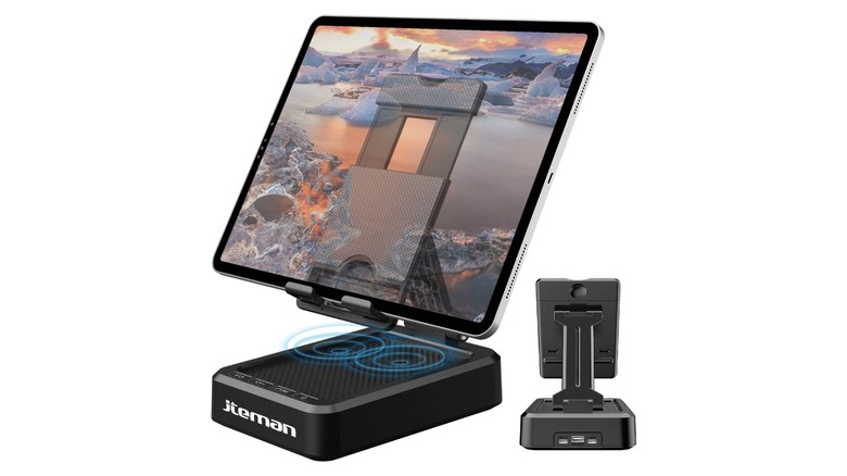 An iPad mounted on a silver stand with a built-in bluetooth speaker in the base.