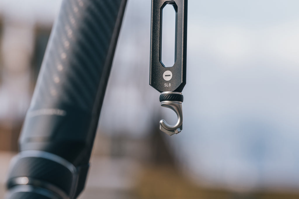 Macro view of a tripod center column hook designed for hanging weight.