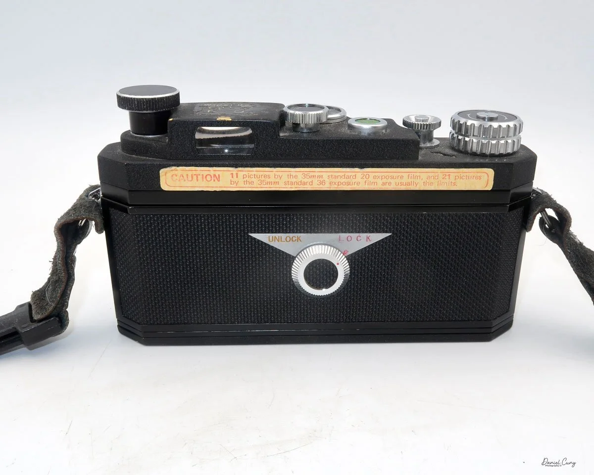 Close-up detail of a Widelux camera showing the specific path film takes around the guide rollers.