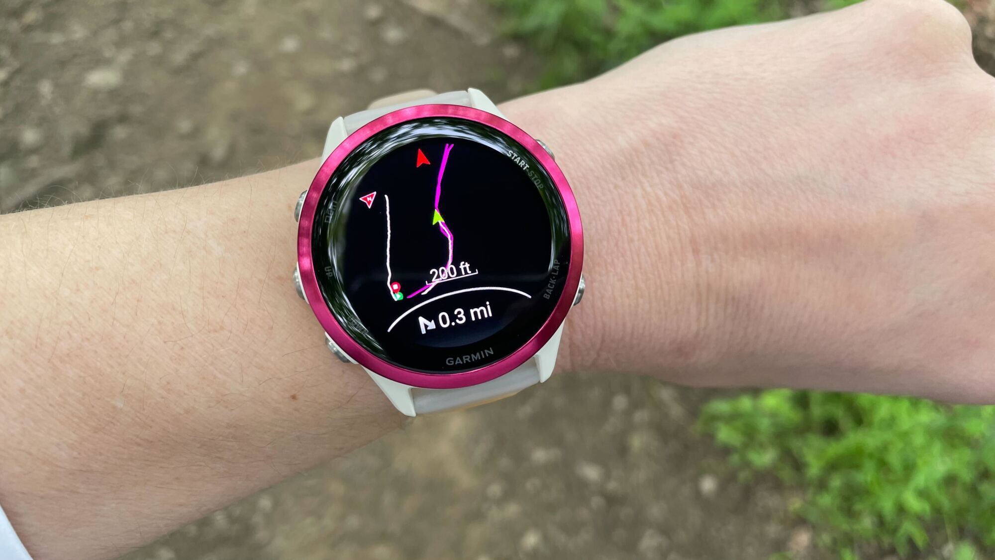 Close-up of a Garmin smartwatch displaying a colorful topographic map and navigation route.