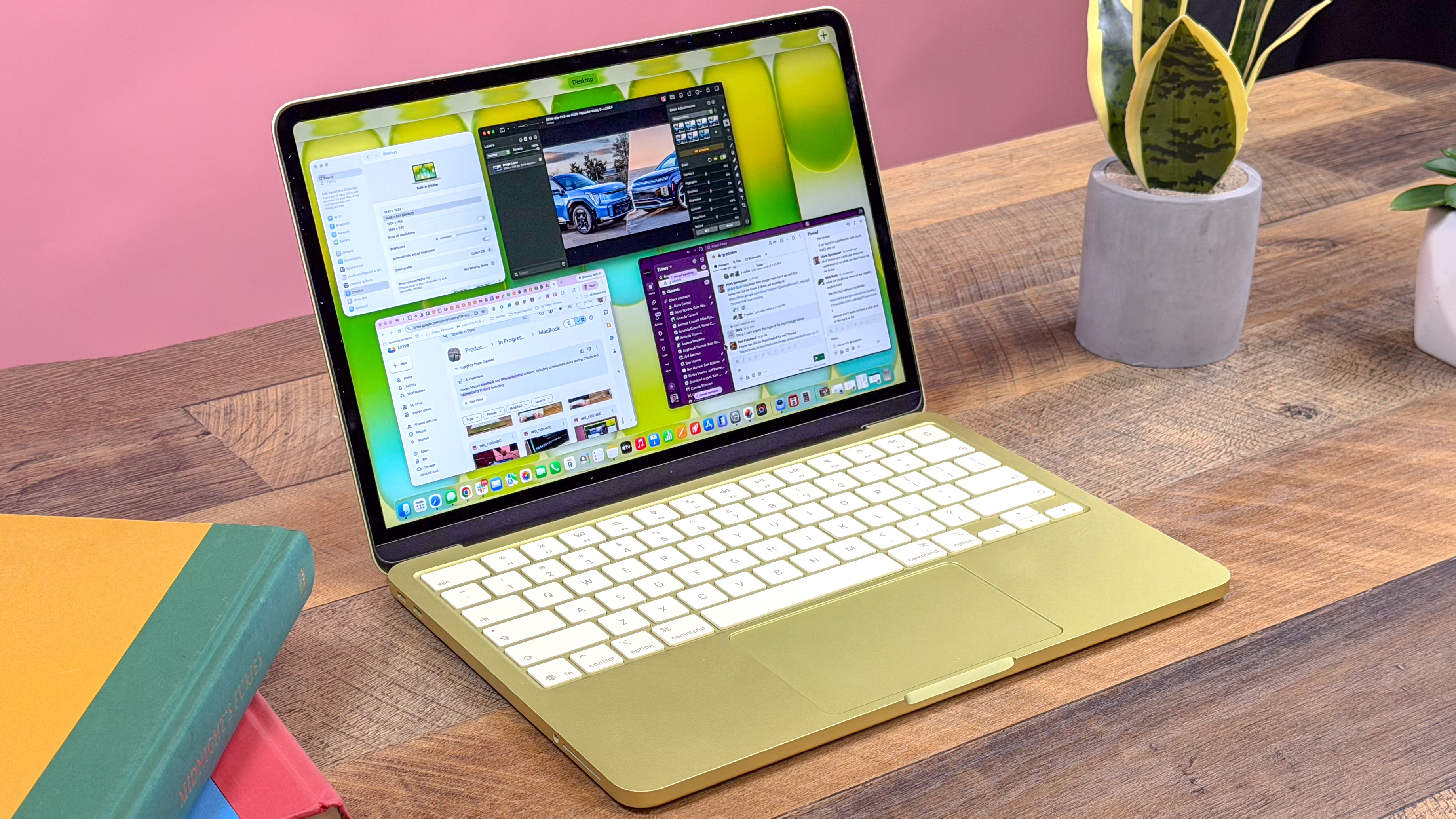 The MacBook Neo open on a table showing its colorful aluminum body and 13-inch display.