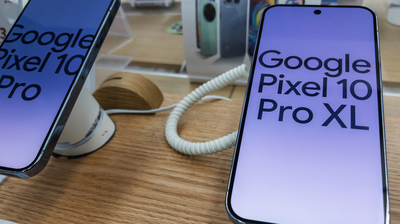 A close-up view of the Google Pixel 10 Pro and 10 Pro XL smartphones displayed in a retail store with bright studio lighting emphasizing their screens.