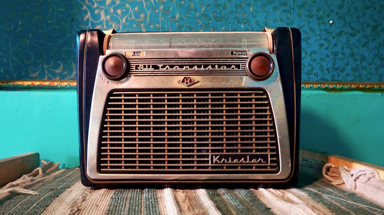 A close-up of a 1950s-era portable transistor radio with tactile tuning knobs.