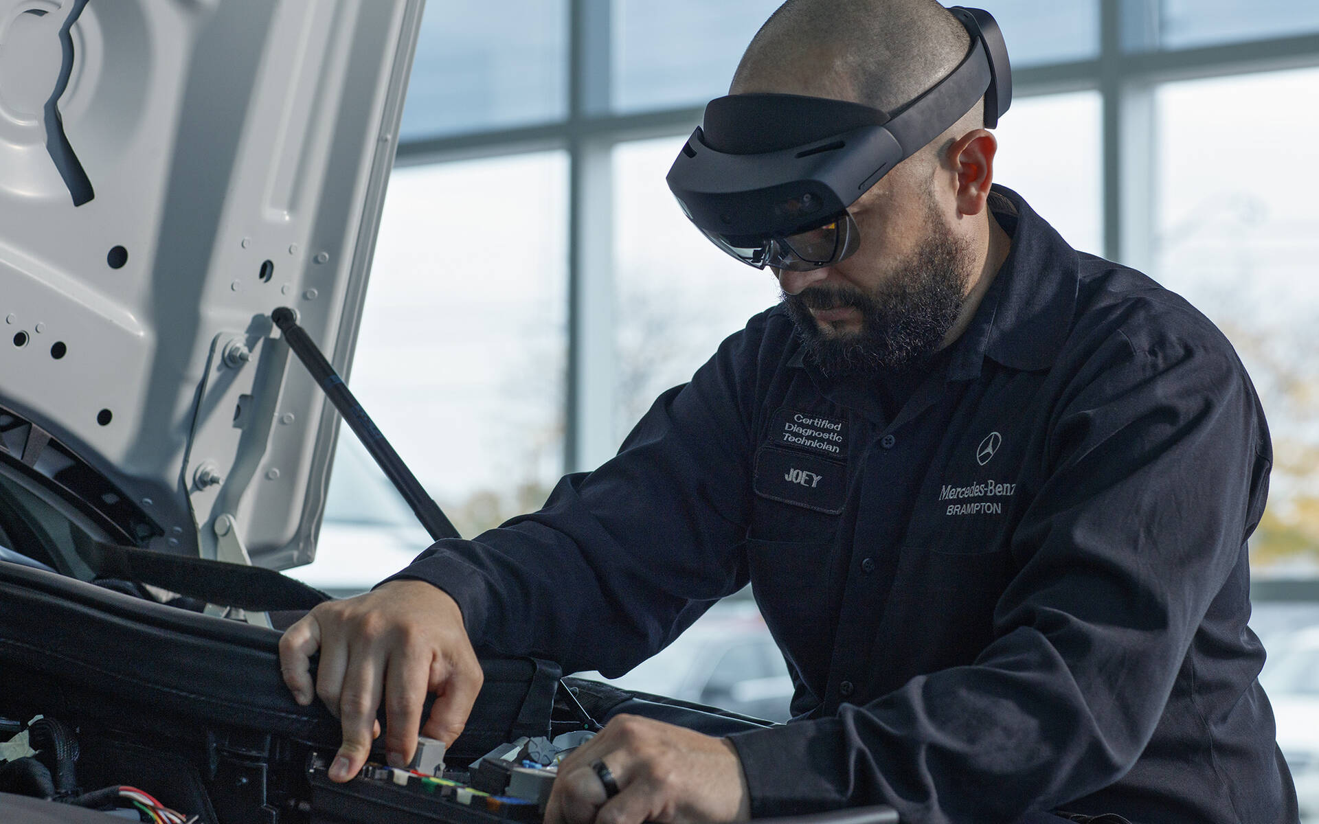 A Mercedes-Benz technician using spatial AR for remote collaborative maintenance on a vehicle.