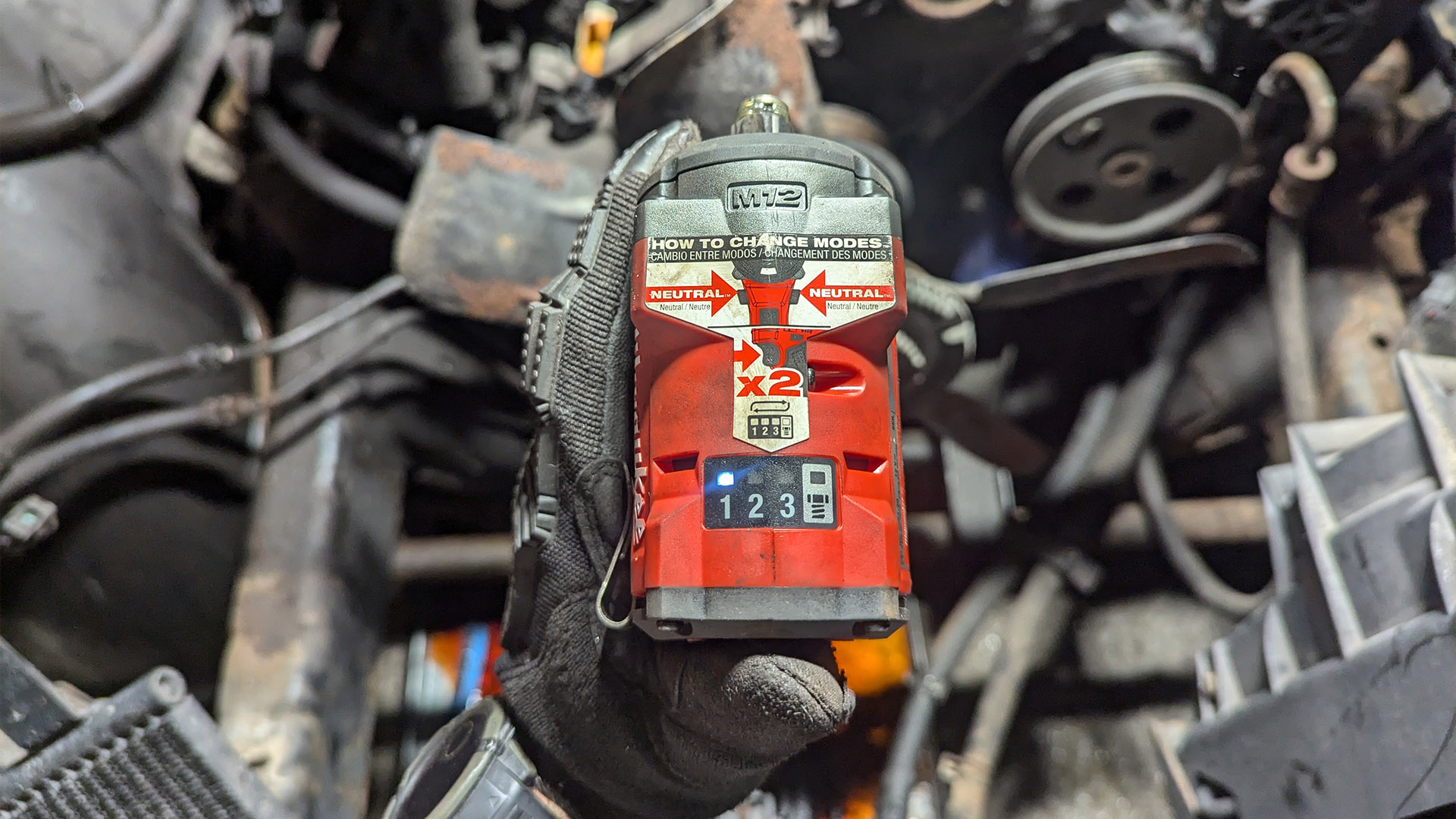 Detailed view of the LED mode selector and trigger on the Milwaukee M12 impact wrench.
