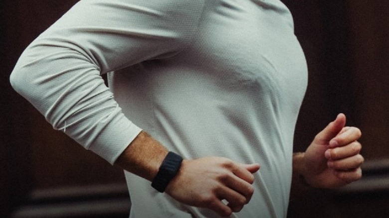 A fitness tracker band on a runner's wrist.