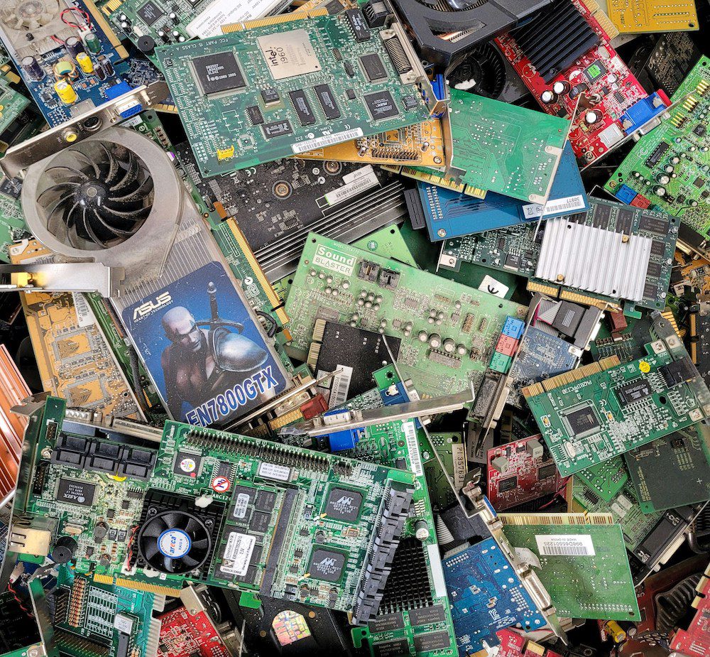 A large pile of discarded electronic devices including old monitors and wires.