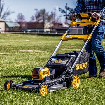 The DeWalt 60V Max electric lawn mower parked on a lawn.