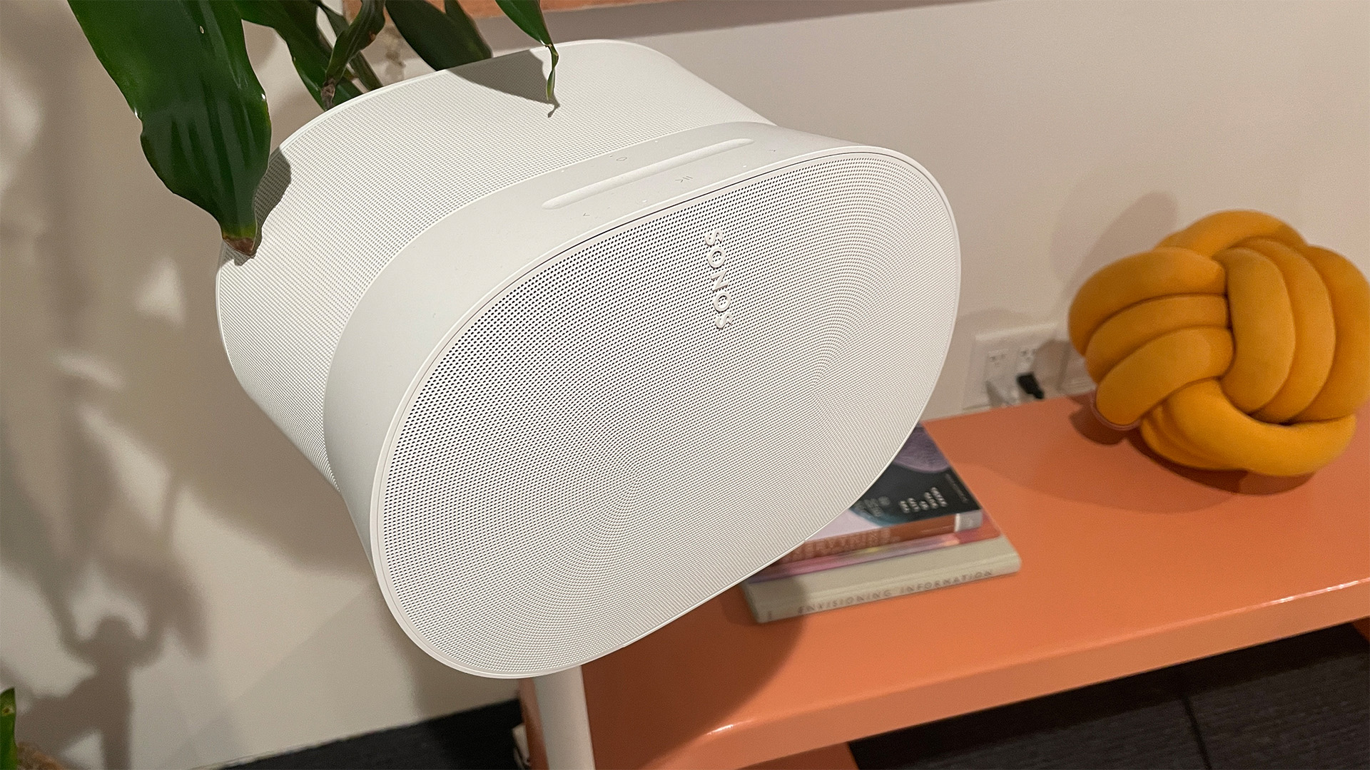 White Sonos Era 300 speaker positioned on a wooden countertop.