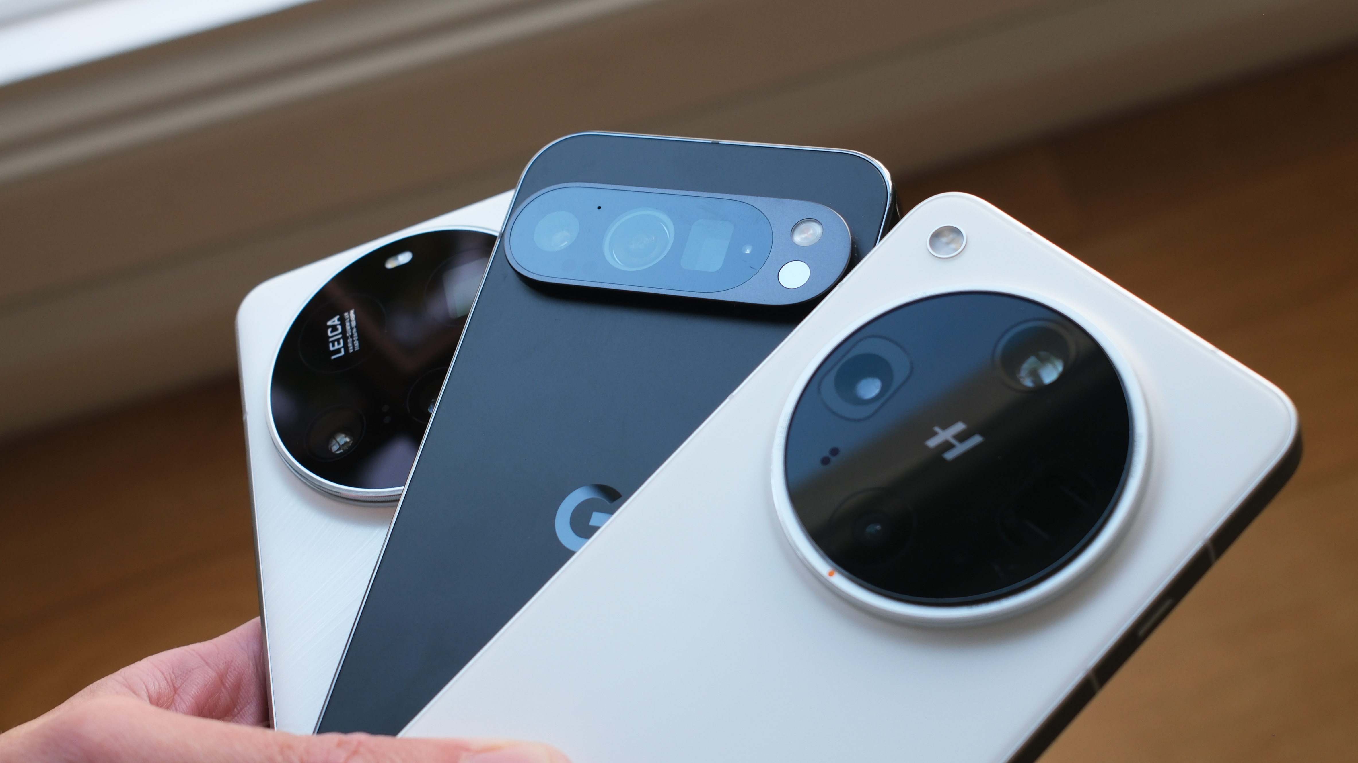 Three different flagship smartphones from Google, Oppo, and Xiaomi placed side-by-side.