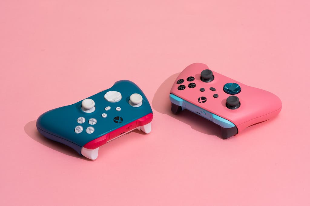 Two customized Microsoft Xbox controllers in vibrant pink and blue colors.