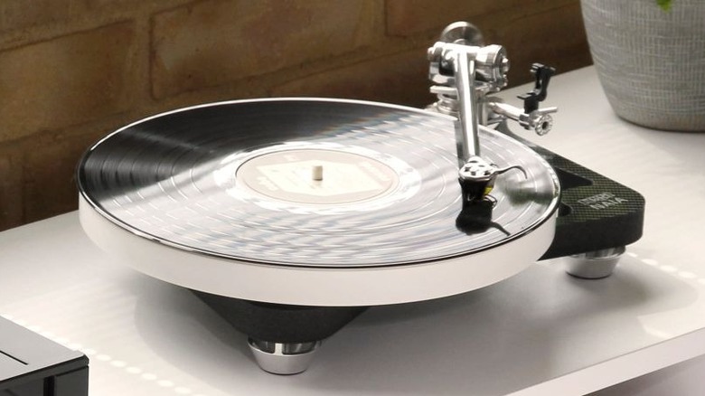 A white Rega turntable with a minimalist plinth and tonearm setup.