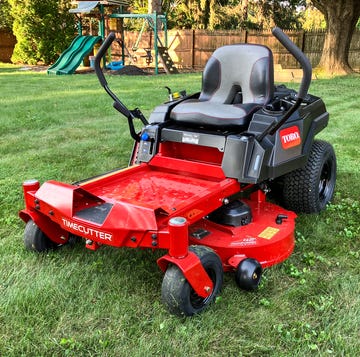 A Toro TimeCutter zero-turn riding mower on a well-manicured lawn.