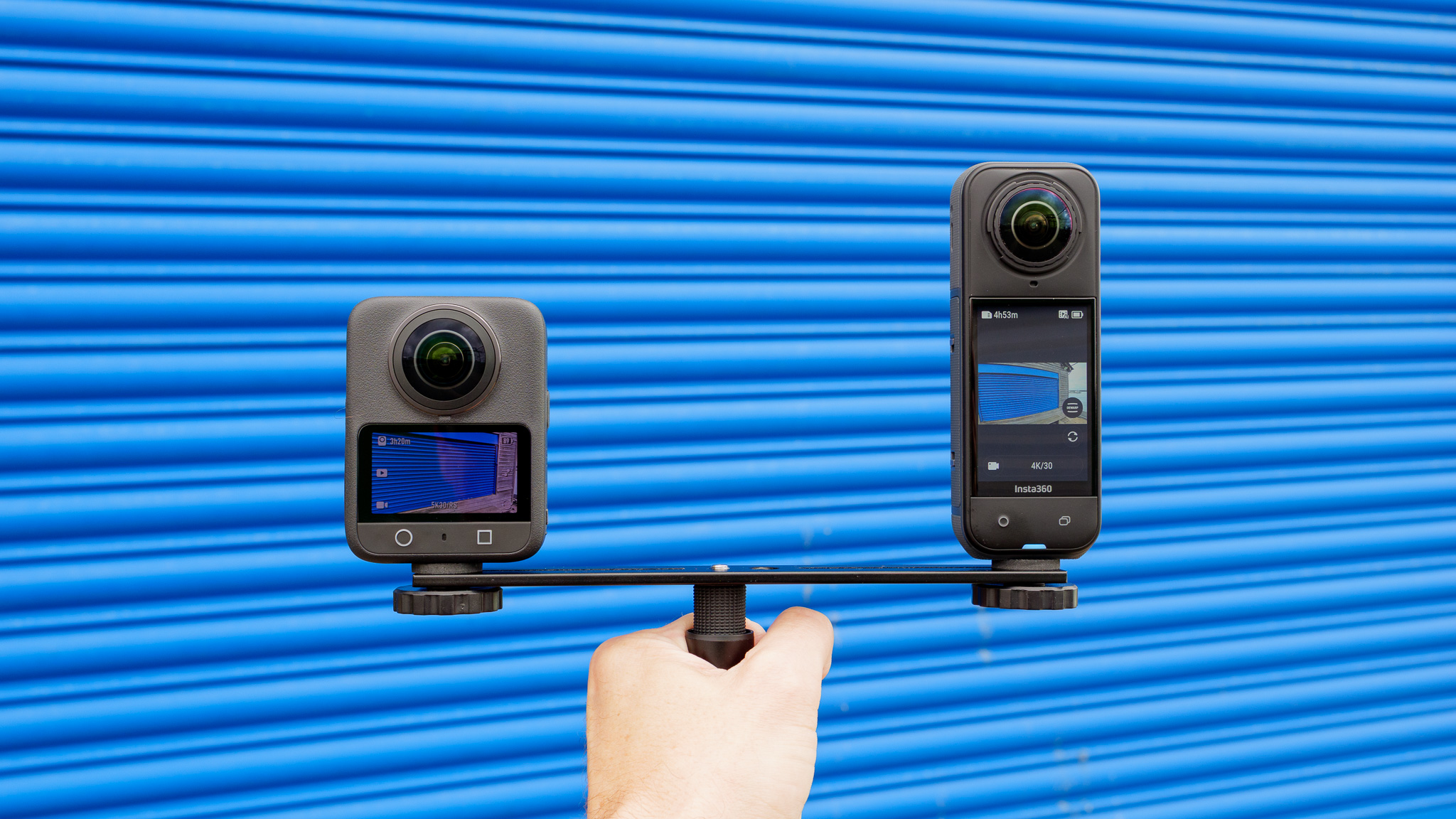 DJI Osmo 360 and Insta360 X5 mounted on a specialized dual-camera bracket.